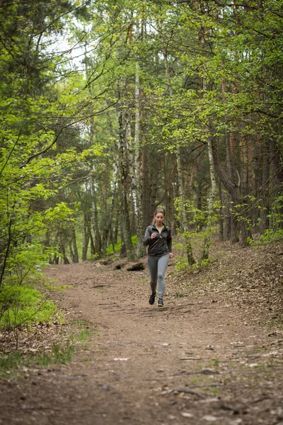 Løpende kvinne i skogen – stockfoto