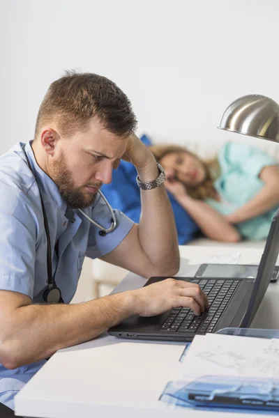 Doctor werkt in de buurt van laptop — Stockfoto