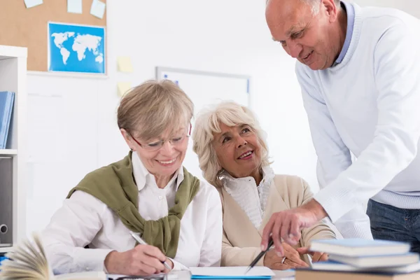 Teacher helping elder student — Stock Photo, Image