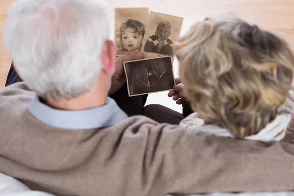 Пожилые люди смотрят на старые фотографии — стоковое фото
