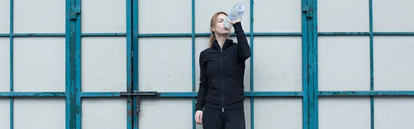 Woman drinks water after training — Stock Photo, Image