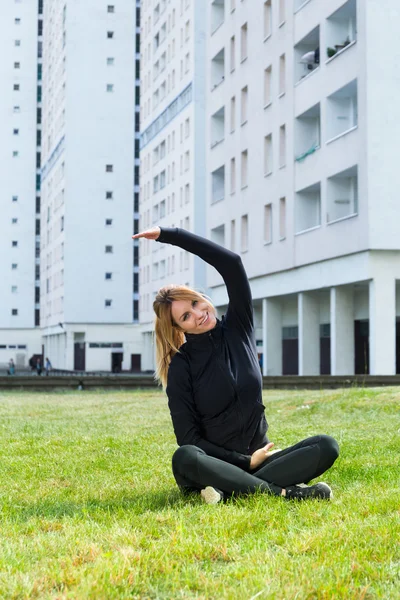 Mujer estirándose sobre la hierba — Foto de Stock