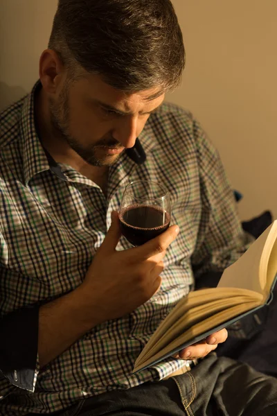 man with book and wine