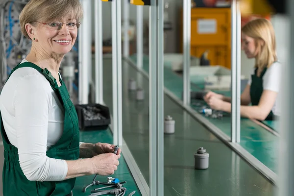 Elderly woman in factory — Stock Photo, Image