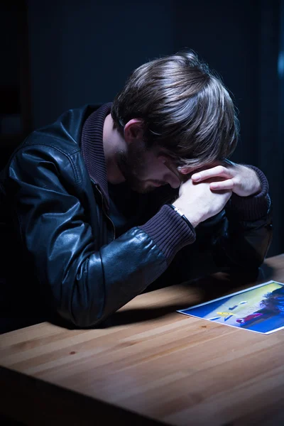 Trauriger Mann schaut auf Bild — Stockfoto