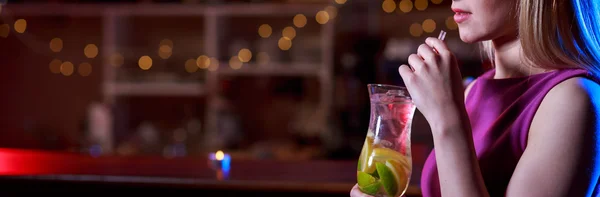 Женщина пьет вкусный коктейль в баре — стоковое фото