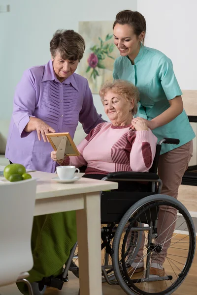 Women and young nurse looking at photo Stock Image