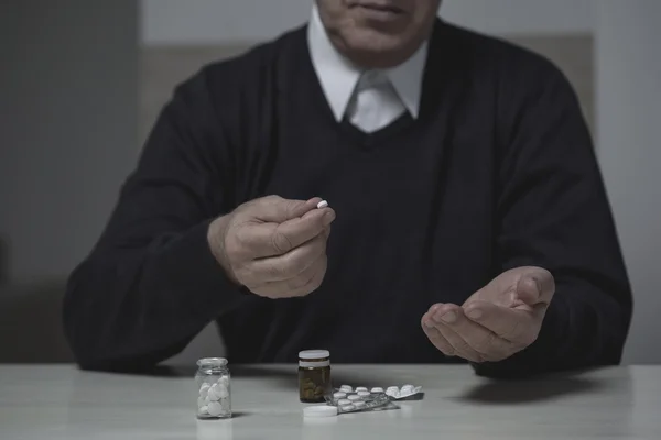 Pensioner taking pills — Stock Photo, Image