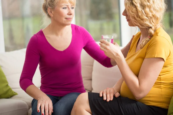 Femme enceinte tenant un verre d'eau — Photo