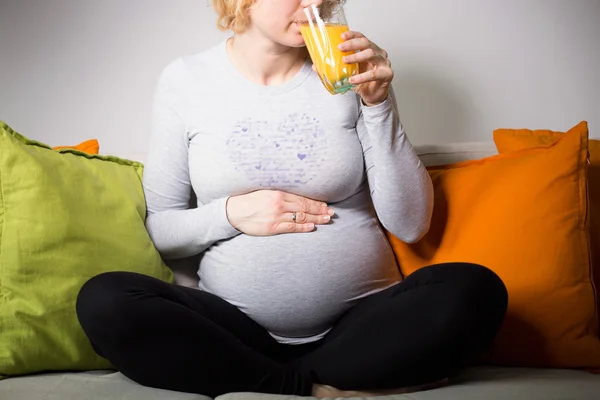 Futura mãe relaxante no sofá — Fotografia de Stock