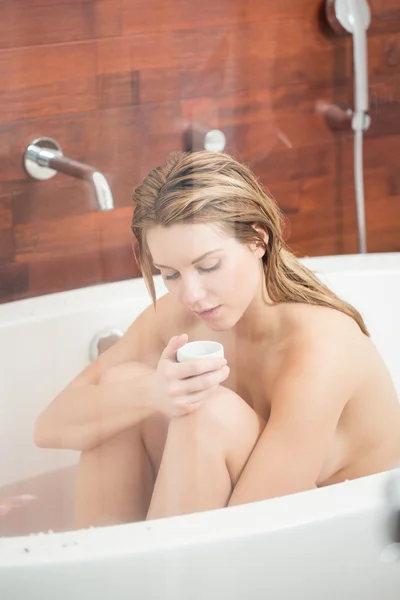 Женщина нюхает масло в ванной — стоковое фото