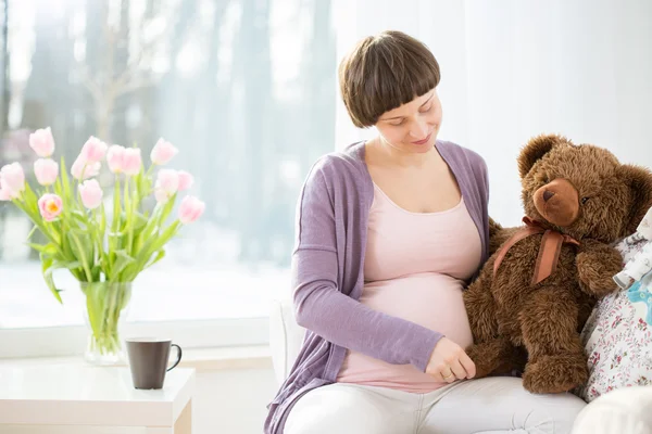 Mujer embarazada con oso de peluche — Foto de Stock