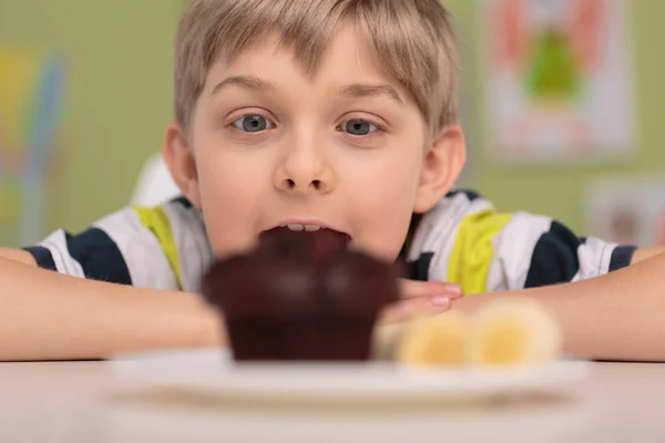 Chciwy chłopiec i muffin — Zdjęcie stockowe