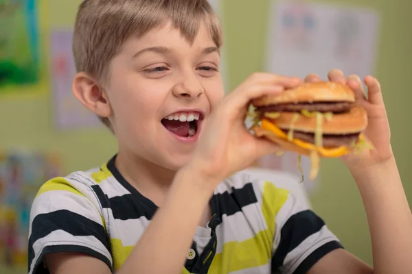 Jongen en vette hamburger — Stockfoto