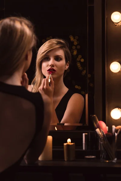 Mädchen trägt roten Lippenstift auf — Stockfoto