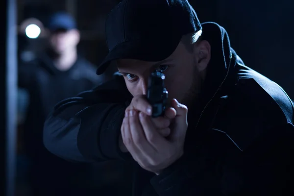 Policeman aiming gun during intervention — Stock Photo, Image