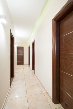 Bej koridorda ahşap kapılar