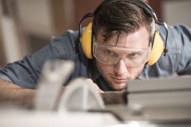Carpenter using protective headphones clipart