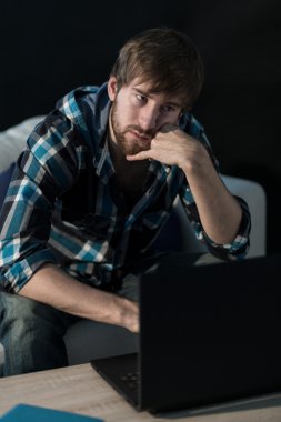 laptop ile oturan üzgün bir adam 