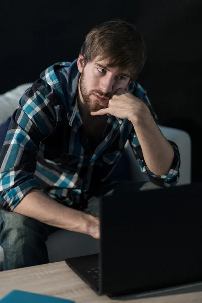 Hombre triste sentado con el ordenador portátil — Foto de Stock