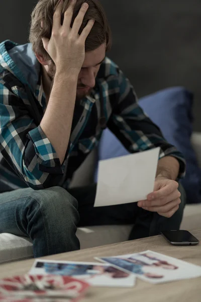 Homem triste olhando para fotos — Fotografia de Stock