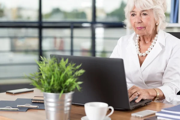 Ältere Büroangestellte mit Laptop — Stockfoto