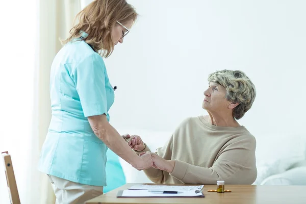 Médico visitando a su viejo paciente —  Fotos de Stock