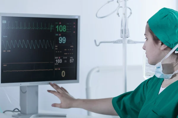 Surgeon looking at medical monitor — Stock Photo, Image