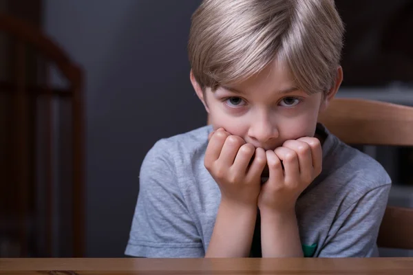 Verängstigtes Kind sitzt am Tisch — Stockfoto