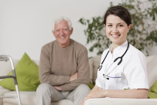 Médico sonriente durante la visita domiciliaria — Foto de Stock