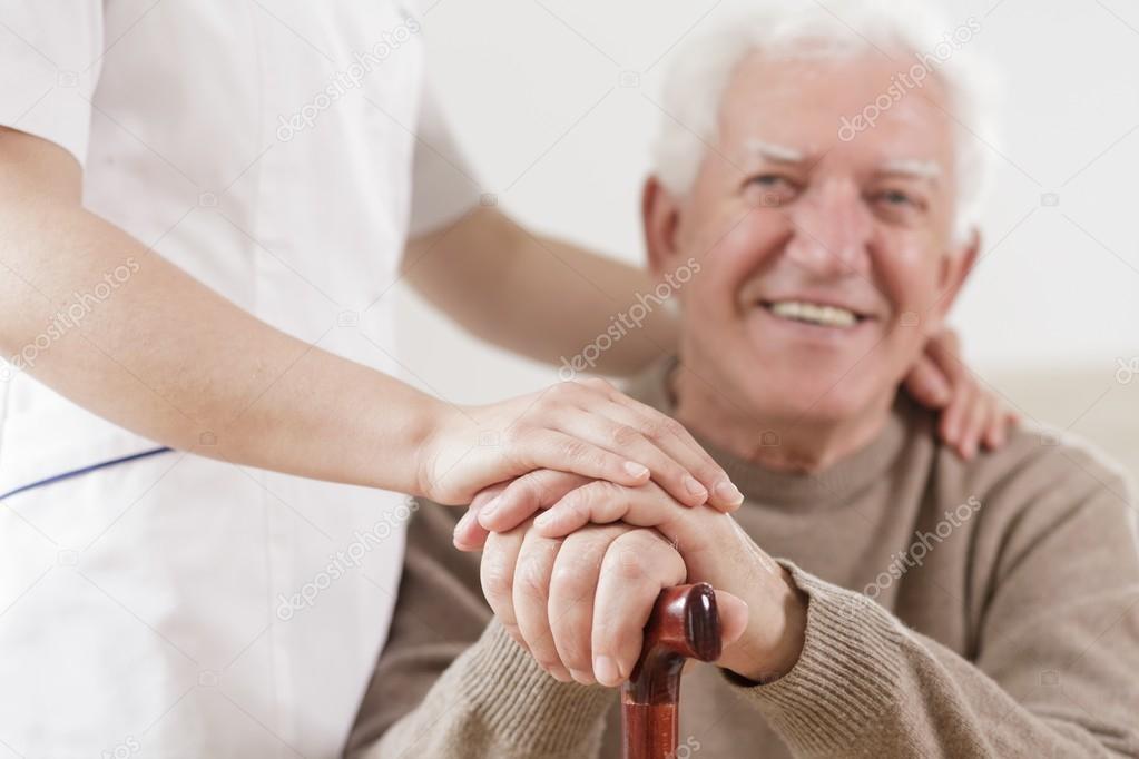 Senior man and helpful nurse