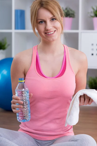 Fit woman holding towel and bottle — Stock Photo, Image