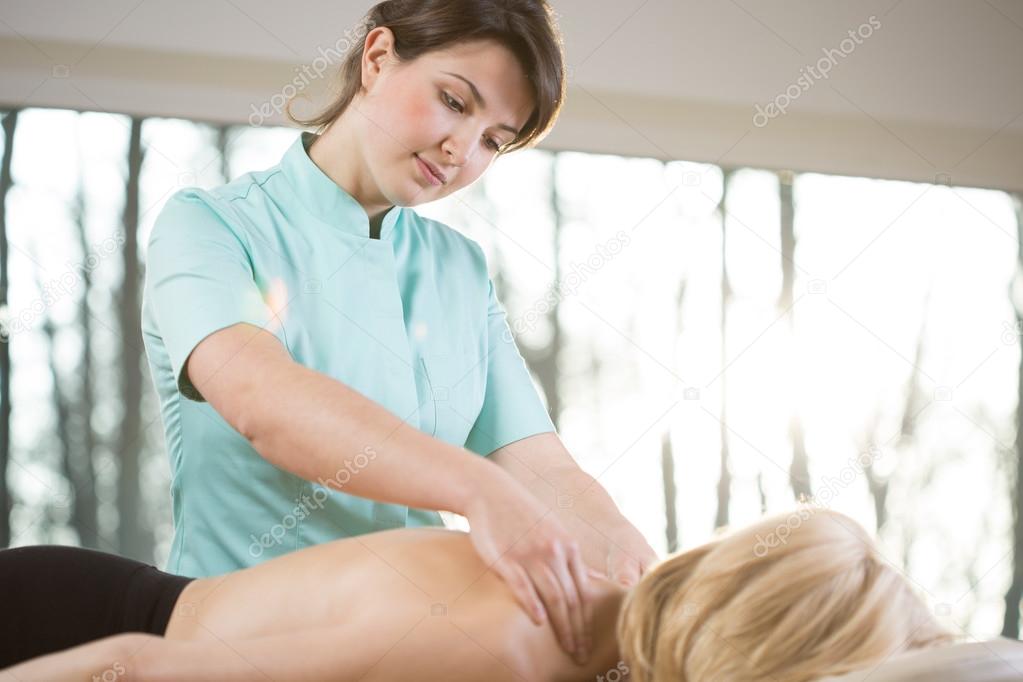 Young physiotherapist massaging