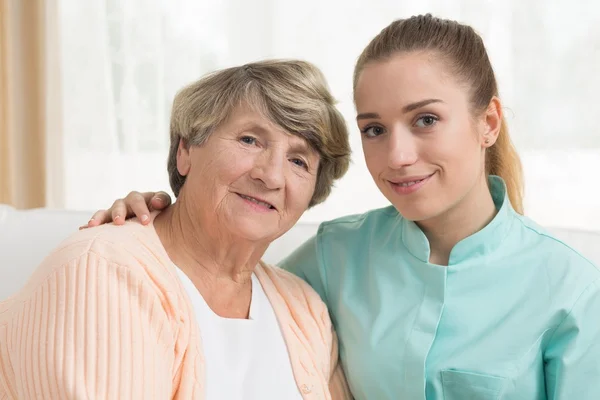Lächelnde alte Frau und Pflegerin — Stockfoto