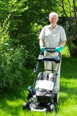 yaşlı adam bir çim mows