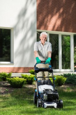 yaşlı adam bir çim mows