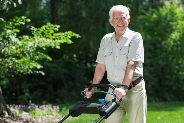 Älterer Mann mäht Rasen — Stockfoto