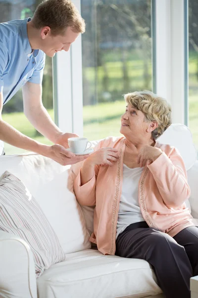 Male nurse giving tea — Stock Photo, Image