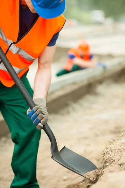 Budowy pracownik gospodarstwa łopata — Zdjęcie stockowe