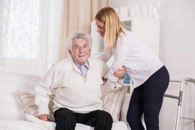 Care assistant helping senior man clipart