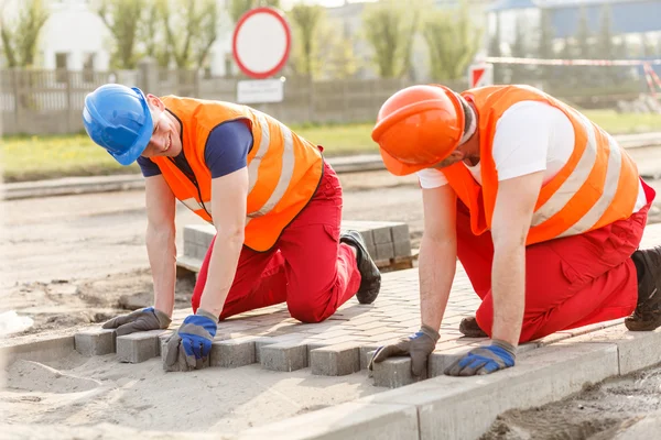 Travailleurs de la construction pose de pavés — Photo