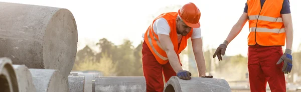 Werknemers in de bouw rollen concrete cirkel — Stockfoto