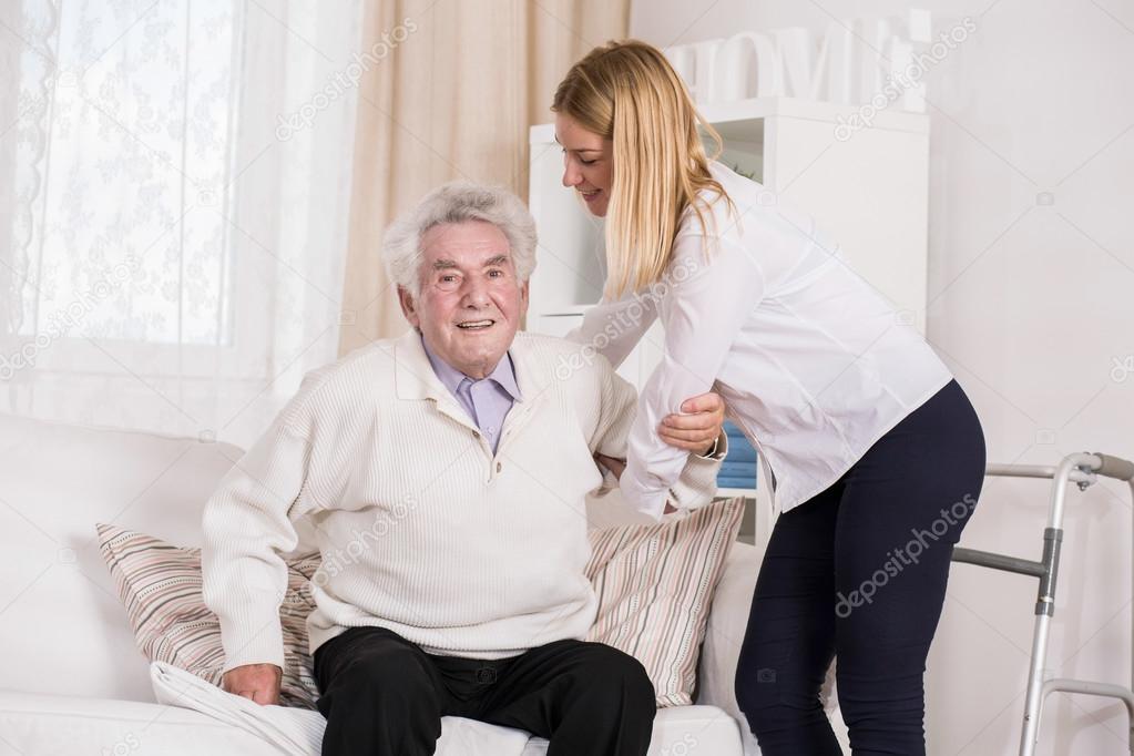 Care assistant helping senior man