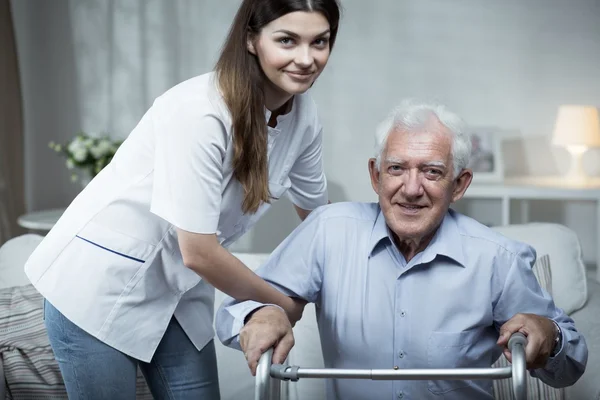 Enfermeira ajudando o idoso deficiente — Fotografia de Stock