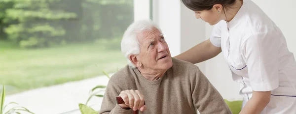 Nurse helping senior man — Stock Photo, Image