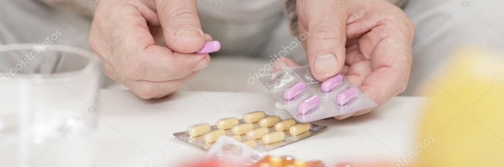 Ill person taking pink pills