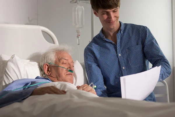Petit-fils rendant visite à grand-père en hospice — Photo