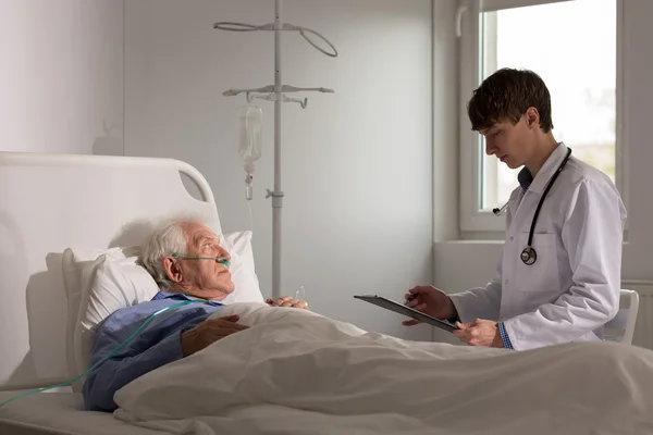 Jonge dokter praten met patiënt — Stockfoto