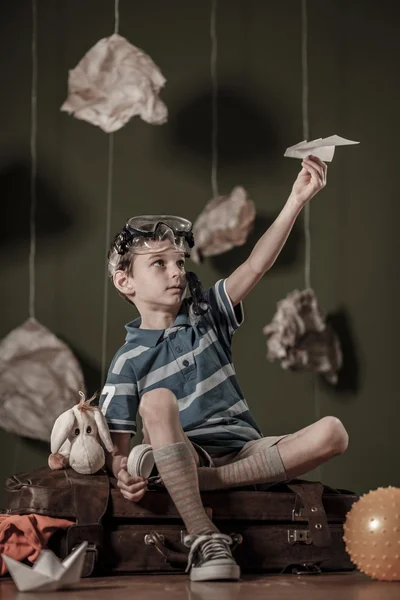 Хлопчик грає з паперовим літаком — стокове фото