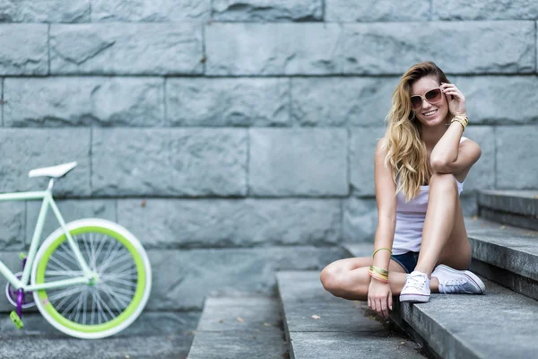 Chica sonriente sentada en las escaleras — Foto de Stock